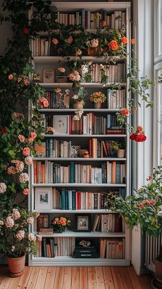 a bookshelf filled with lots of books next to a window covered in plants