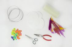 the supplies needed to make this craft include scissors, thread, and paper flowers on a white background