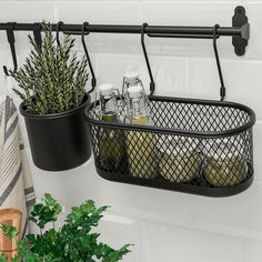 two black metal baskets holding bottles and plants