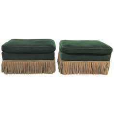 a pair of green velvet footstools with fringes