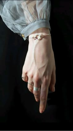 a woman's hand wearing a silver bracelet