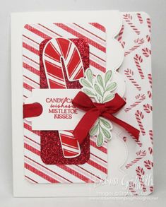 a card with candy canes on it and a red ribbon tied around the edge