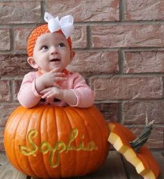 a baby sitting on top of a pumpkin with the word splish written on it