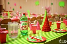 the table is set with pink and green paper hats, cups, and napkins