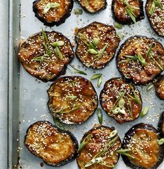 an overhead view of some cooked food on a baking sheet with sesame seeds and sprinkles