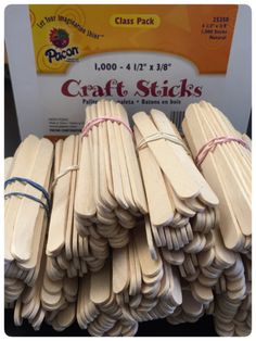 several wooden sticks are stacked on top of each other in front of a sign that says craft sticks