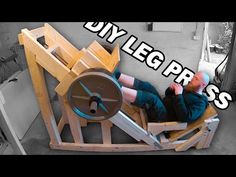 a man sitting in a chair made out of wood with the words diy leg press on it