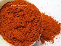 a white bowl filled with red powder on top of a table