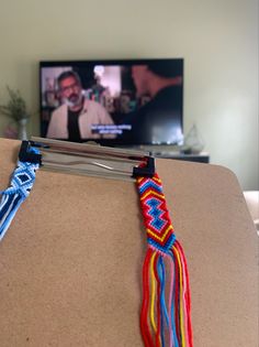 there is a tv that is on in the background and some colorful cords hanging from it