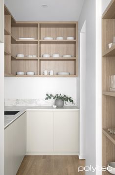 a kitchen with white cabinets and wooden shelves