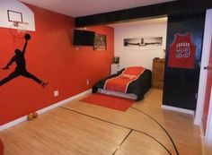 a bedroom decorated in red and black with a basketball painted on the wall