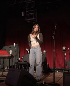 a woman standing on top of a stage holding a microphone