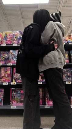 two people standing in front of shelves with toys