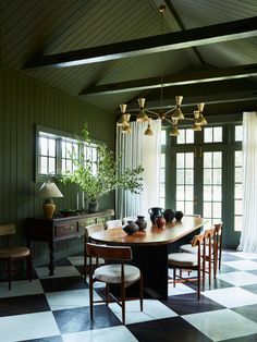 a dining room with checkered flooring and wooden table surrounded by four stools