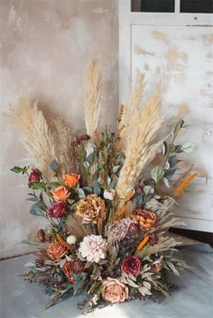 a vase filled with lots of flowers on top of a table