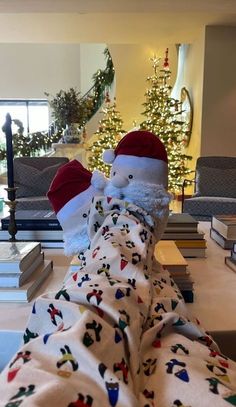 a stuffed animal wearing a santa hat on top of a bed next to a christmas tree