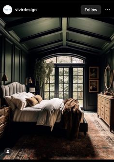 a bedroom with dark green walls and wooden furniture, along with a large window that opens to the outdoors