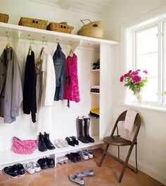 a closet with shoes and clothes hanging on the wall