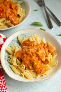 two bowls filled with pasta covered in sauce