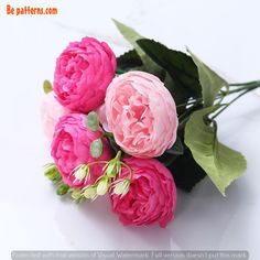 three pink flowers with green leaves on a white surface