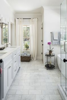 a large bathroom with white tile floors and walls