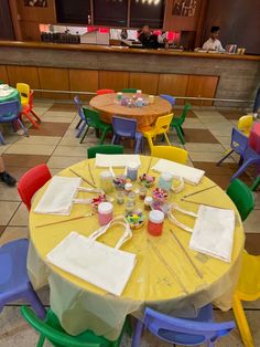 tables and chairs are set up for a birthday party with cupcakes on them