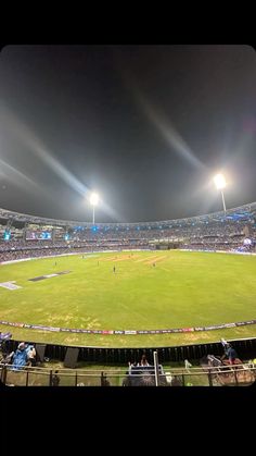 an empty baseball stadium at night with bright lights on the field and fans in the stands