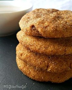 three cookies stacked on top of each other next to a bowl of milk