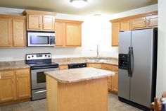 a kitchen with stainless steel appliances and wooden cabinets