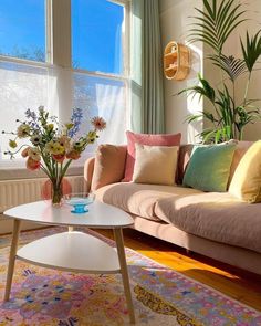 a living room filled with lots of furniture and flowers on top of a coffee table