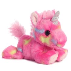 a pink stuffed animal with a unicorn horn on it's head and tail, laying down