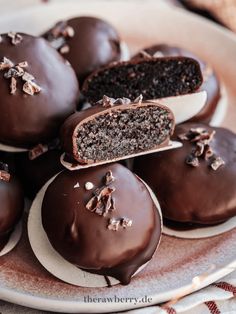 chocolate covered cookies on a plate with one cut in half and the other partially eaten