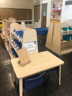 an empty classroom with wooden desks and blue chairs