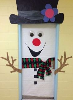 a door decorated to look like a snowman wearing a top hat and scarf with antlers