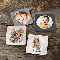 four square coasters with pictures of people and a wine glass on a wooden table