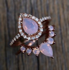 an image of two rings with pink stones on top of each other and diamonds in the middle