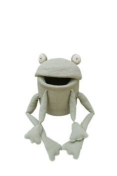 a knitted frog hat with eyes and ears on it's head, sitting in front of a white background