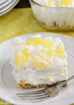 a piece of cake on a plate with a fork and glass bowl in the background