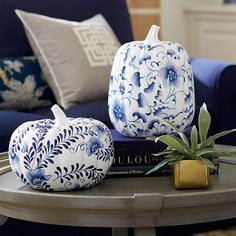 two blue and white pumpkins sitting on top of a table