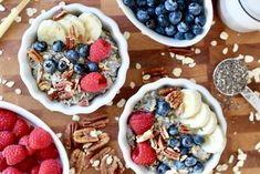 two bowls filled with oatmeal and fruit on top of a wooden table