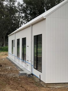 a small white building sitting on top of a dirt field