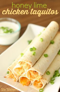 two chicken taquitass on a white plate with ranch dressing in the background