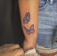 two purple butterflies on the right arm and one is in the middle of the leg