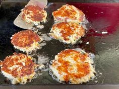 some food is cooking in a pan on top of the stove and being prepared to be cooked