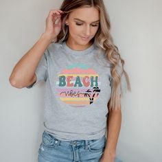 Looking for a cute versatile top to wear? Make sure to grab one of our Graphic tees! This soft and comfortable graphic tee is the perfect top for any outfit. It can be paired with biker shorts, jeans, or even a simple skirt/dress! This tee is true-to-size, so be sure to order your regular t-shirt size! If you are looking for a more oversized look, make sure to size up! Trendy Funny Print T-shirt For Vacation, Trendy T-shirt With Text Print For Vacation, Cute Graphic Print T-shirt For Beach Season, Cute Graphic Print T-shirt For Vacation, Vacation Graphic Tee With Text Print, Trendy Graphic Print T-shirt For Vacation, Trendy Vacation Tops With Text Print, Trendy Tops With Text Print For Vacation, Trendy Vacation Tops With Funny Print