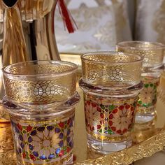 four glasses are sitting on a gold tray