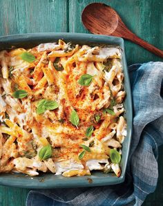 a casserole dish with chicken, spinach and cheese on a blue plate