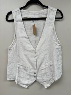 Upgrade your wardrobe with our Italian Linen Vest/Top. Made from luxurious Italian linen, this versatile piece can be worn as a top or a vest, perfect for any occasion. Its front button closure and v neck cut add a touch of elegance, while the two front pockets provide functionality. Experience the perfect balance of fun, elegance, and comfort. Pair it with anything for a sophisticated look. Classic V-neck Tops With Pockets, Linen V-neck Vest For Day Out, Buttoned Summer Vest For Everyday, Spring Linen Vest For Day Out, Summer Vest With Buttons For Everyday Wear, Summer Everyday Vest With Buttons, Summer Everyday Button Vest, Unlined Spring V-neck Top, Elegant V-neck Tops With Pockets