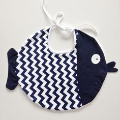 a bib with a fish design on the front and bottom, hanging from a string