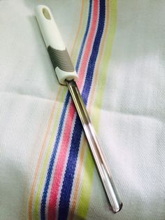 an electric toothbrush sitting on top of a striped towel